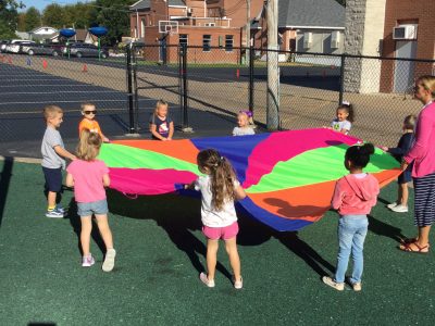 students playing with parachute during gym class